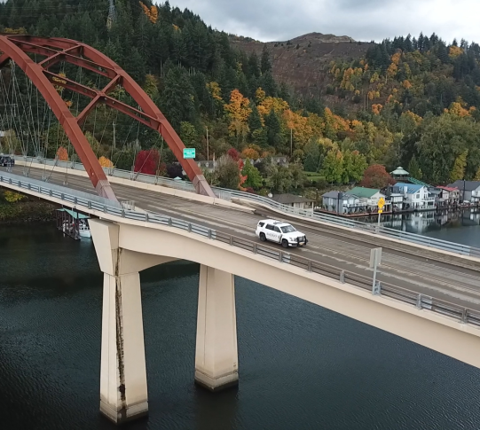 Patrol car drives across Sauvie Island Bridge.