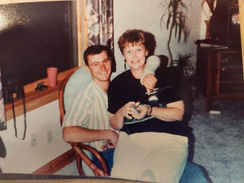 Charly Richards sits in a chair with his mom sitting on his lap.