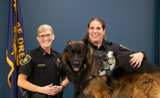 Sheriff, deputy, and Comfort dog pose for a photo.